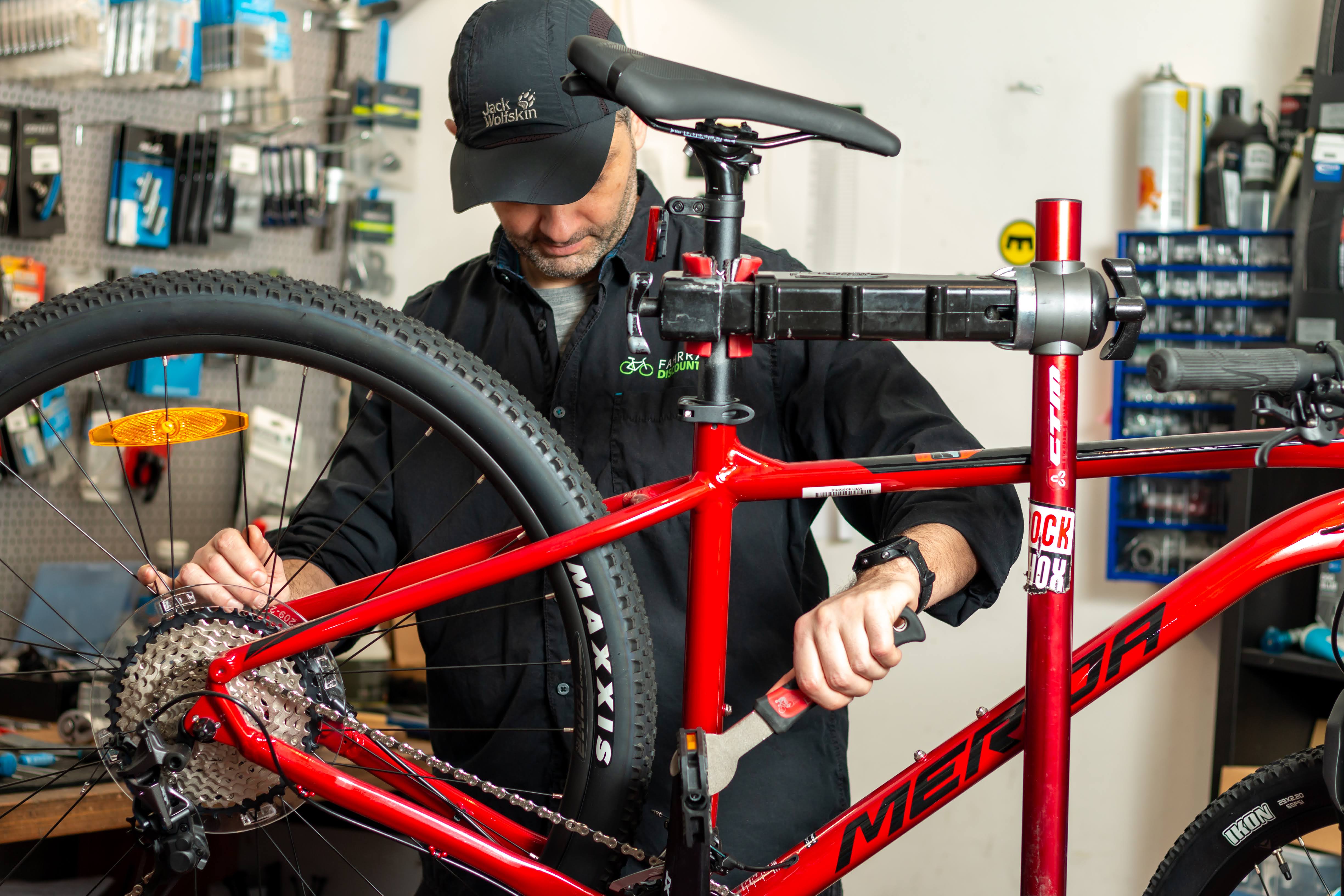 Professioneller Fahrradmechaniker Fahrradmechaniker repariert ein Fahrrad